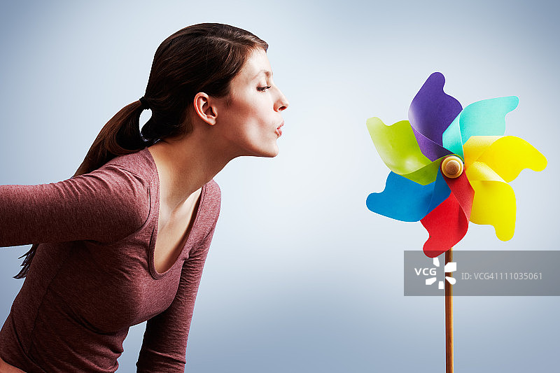 年轻女人吹风车图片素材