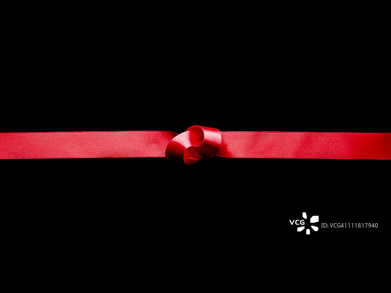 黑色背景上的红色丝带结图片素材