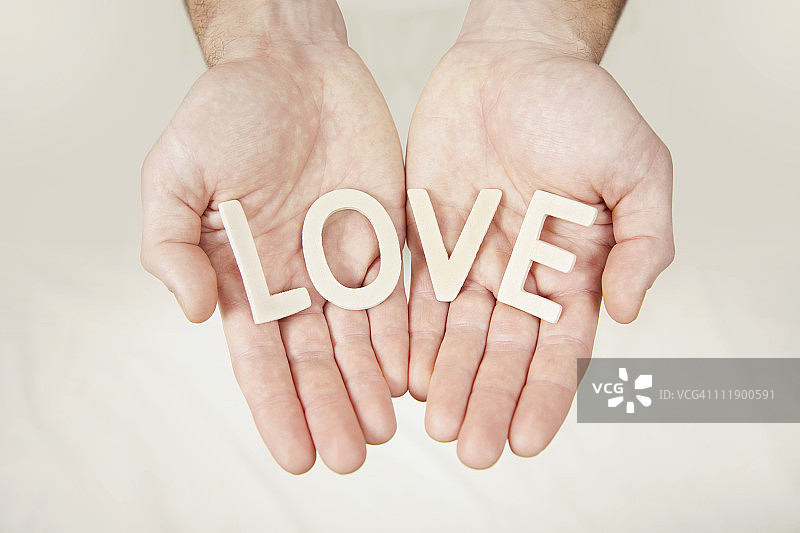 双手拿着拼写单词的字母图片素材