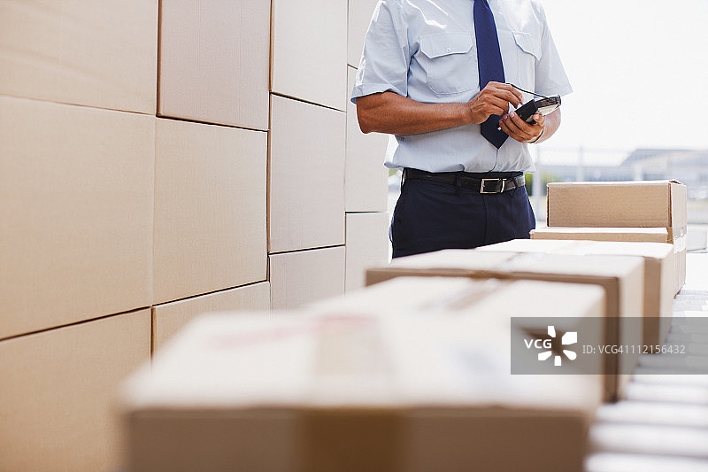工人站在传送带旁的箱子附近图片素材