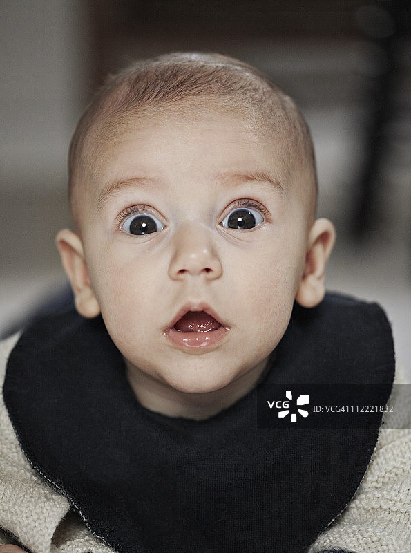 对着镜头露出惊讶表情的男婴特写图片素材