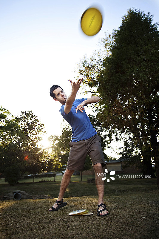 男人在玩飞盘高尔夫，正手击球（逆光，动态模糊）图片素材