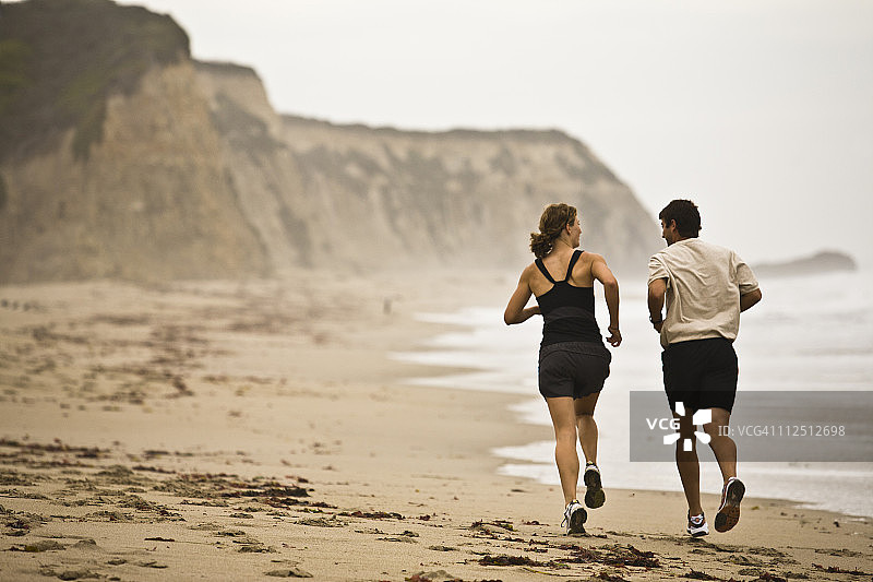 男人和女人在沙滩上跑步图片素材