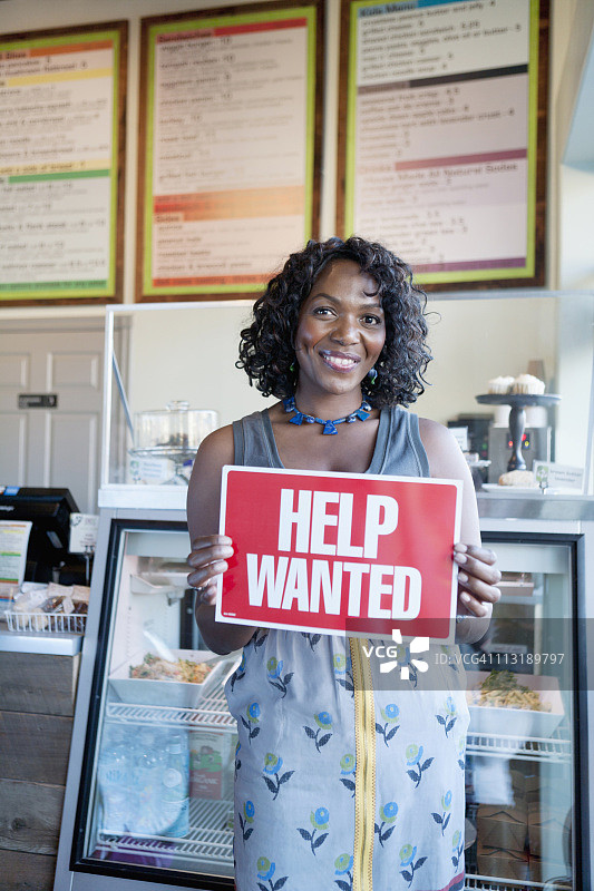 黑人女性在面包店拿着招聘牌图片素材