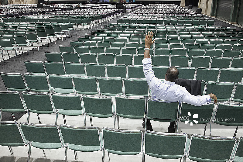 在空旷会议中心挥手的黑人商人图片素材