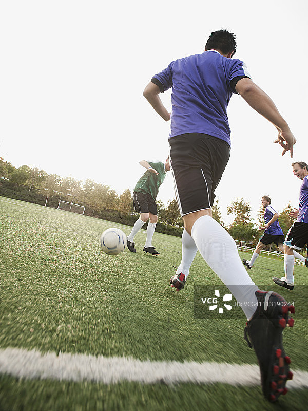 在足球场上踢足球的男人们图片素材