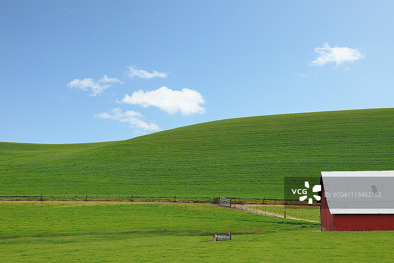 绿色山丘与红色谷仓图片素材