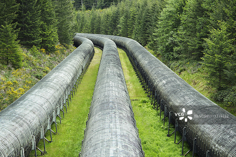 穿过森林的水电站大坝管道图片素材