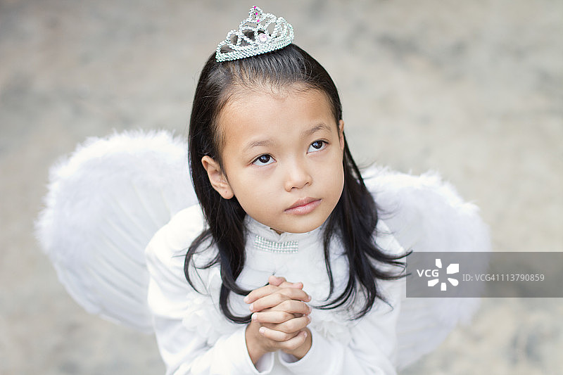 戴着翅膀祈祷的小女孩图片素材