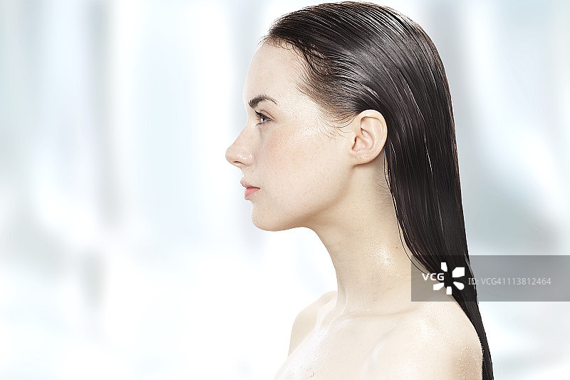 头发湿漉漉的年轻女子侧面照图片素材