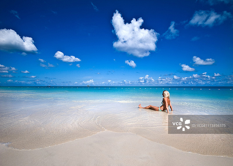 女子躺在海滩的水中图片素材