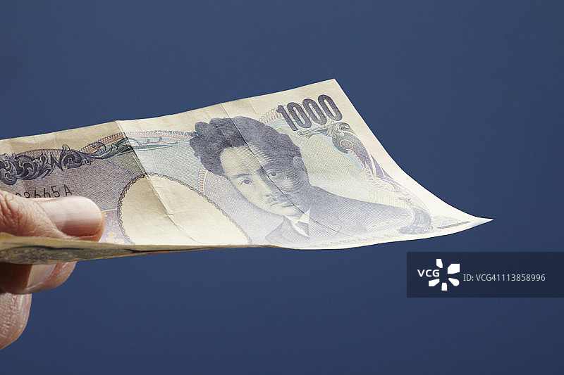 男人手持一千日元纸币图片素材