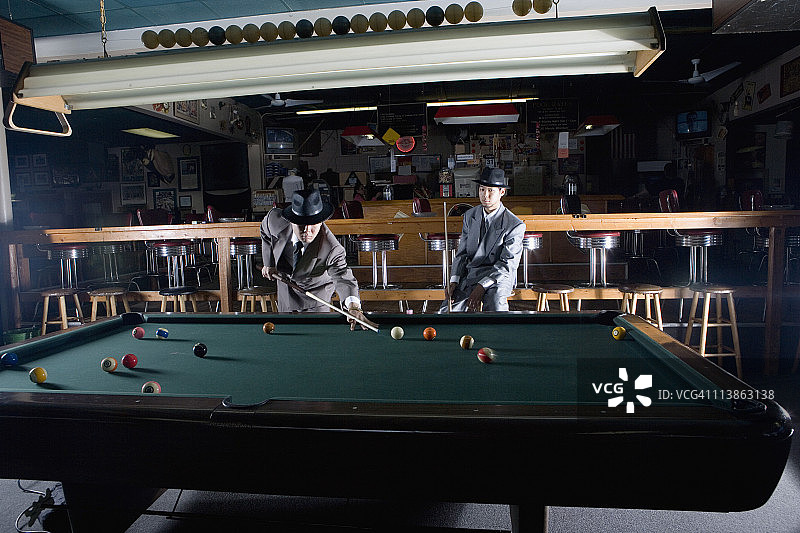 两个戴帽子穿西装的男人在打台球图片素材