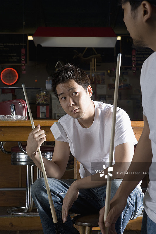 两个穿牛仔裤和T恤的男人拿着球杆图片素材