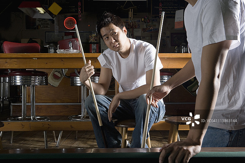 两个穿牛仔裤和T恤的男人拿着球杆图片素材