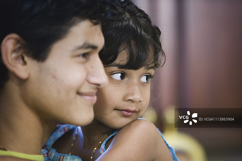 青少年男孩抱着妹妹的特写侧脸图片素材