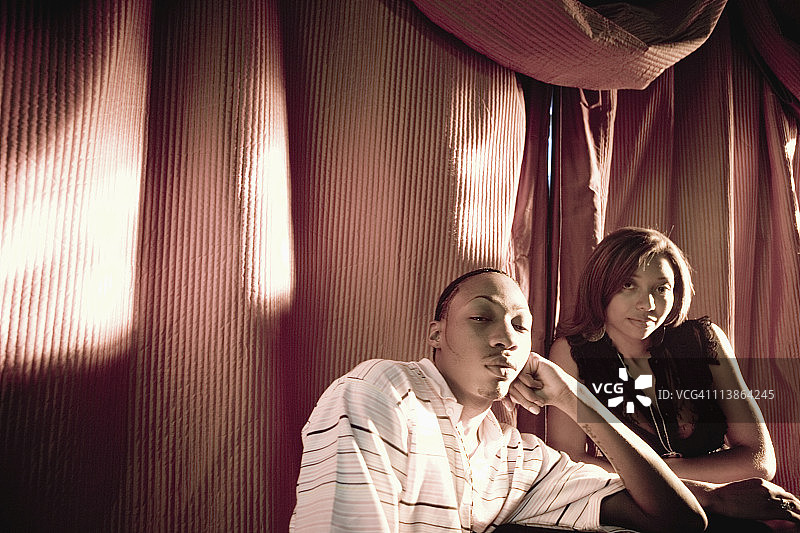 嘻哈风格穿着的年轻情侣坐在桌旁图片素材