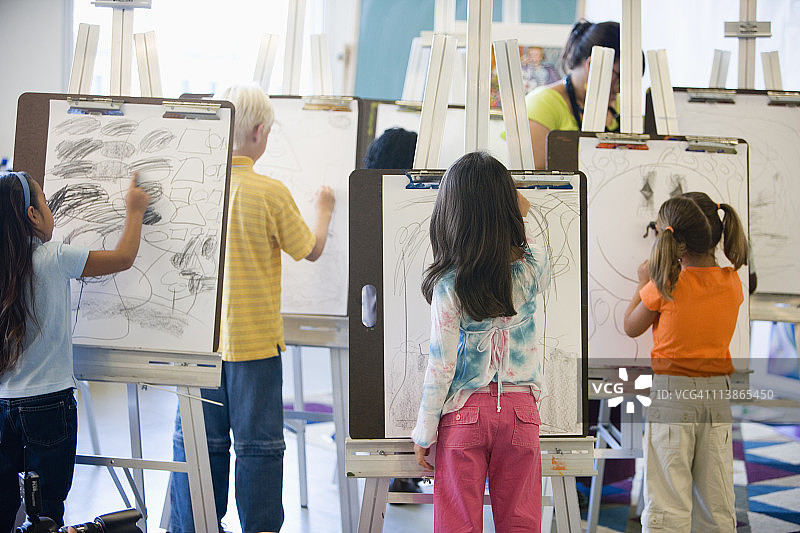 美术课上在画架上绘画的男孩女孩图片素材