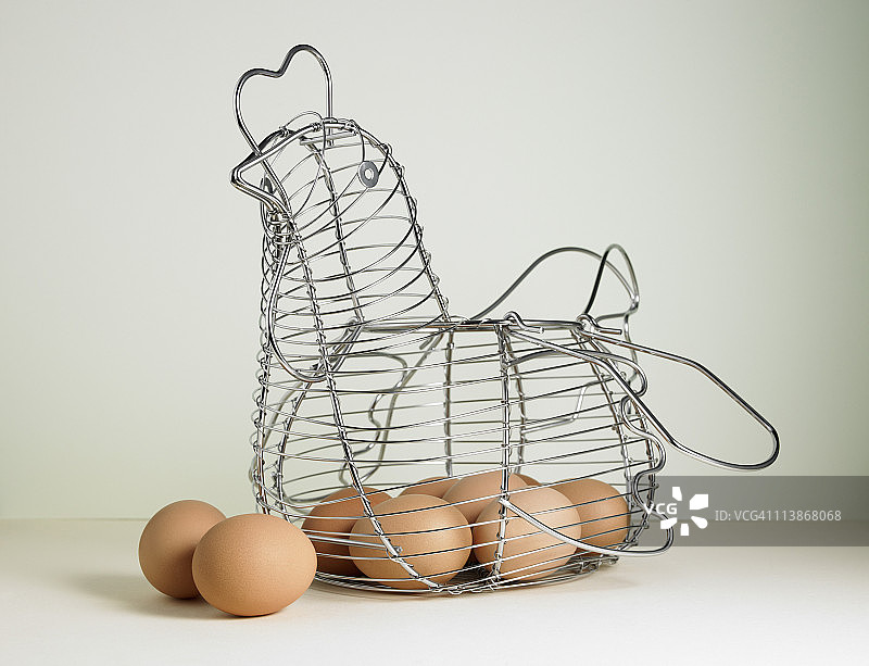母鸡形状金属篮中的棕色鸡蛋图片素材