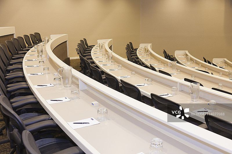 空旷的讲堂，桌上有笔记本和笔图片素材