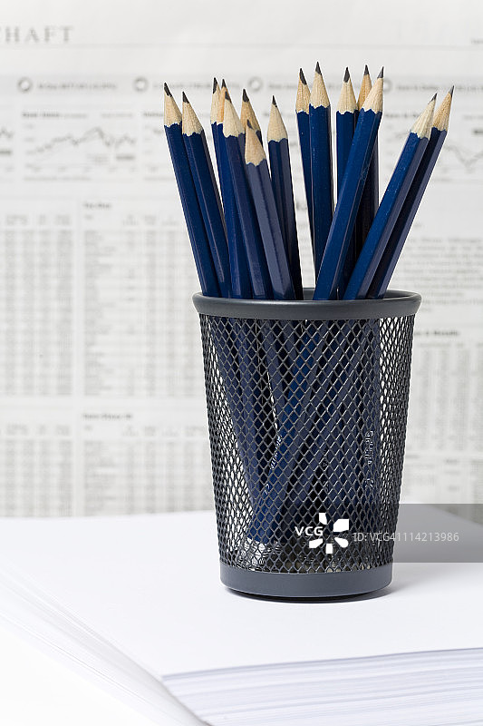 报纸前笔筒里的铅笔和股票价格图片素材