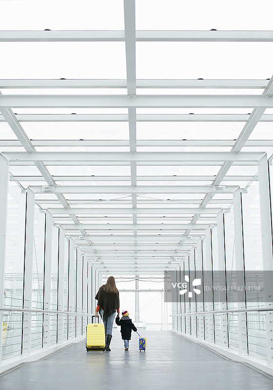 母子携带行李穿过通道，德国巴伐利亚慕尼黑机场图片素材