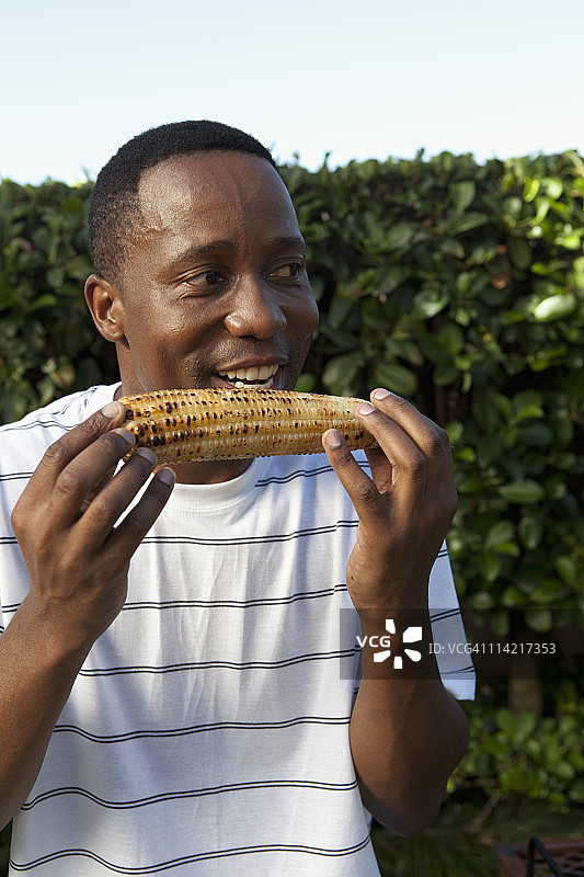 男人在约翰内斯堡吃玉米棒图片素材