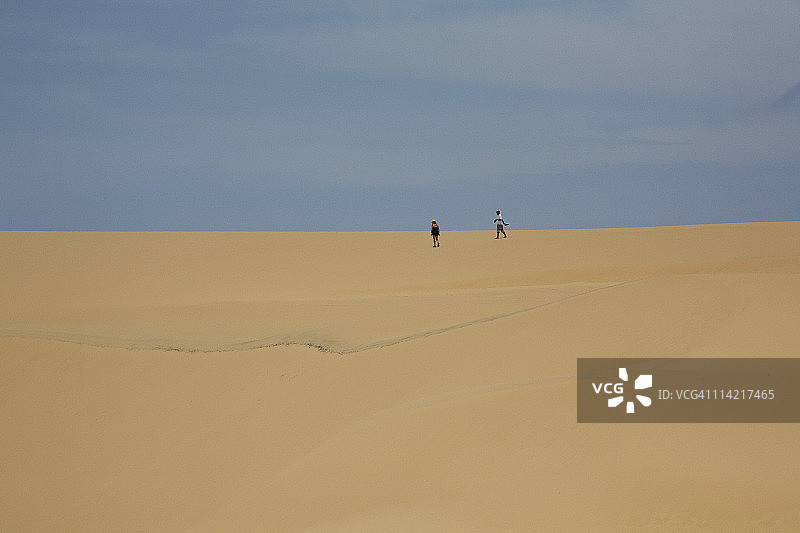 两位游客在莫桑比克巴扎鲁托岛南端的沙丘上行走图片素材