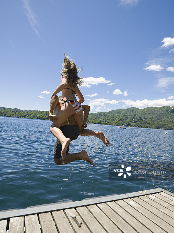 意大利皮埃蒙特：父女在奥尔塔湖码头跳水图片素材
