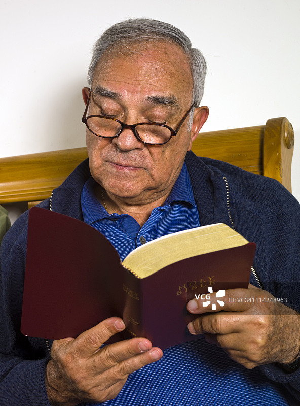 西班牙裔老年男子阅读圣经图片素材