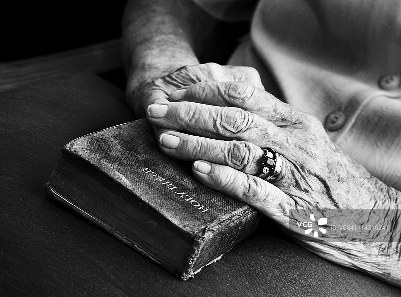 年长者的双手放在旧圣经上图片素材