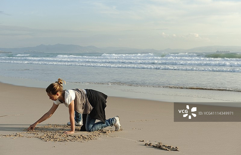 在科斯塔德拉卢斯洛斯兰斯海滩上画画的女孩图片素材