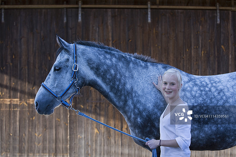 年轻女孩抱着白马的肖像图片素材