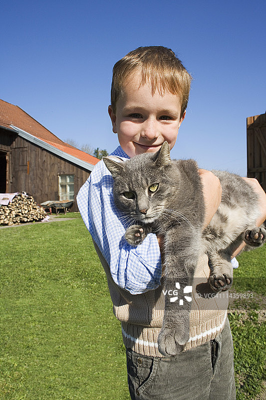 抱着猫的年轻男孩肖像照图片素材