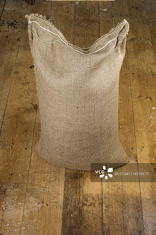 旧木地板上的粗麻布袋图片素材