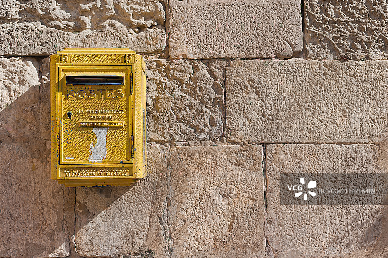 石头墙上的法国黄色“Postes”邮箱图片素材