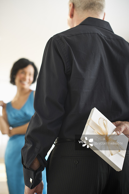 美国新泽西州新泽西市，男子把礼品盒藏在背后图片素材