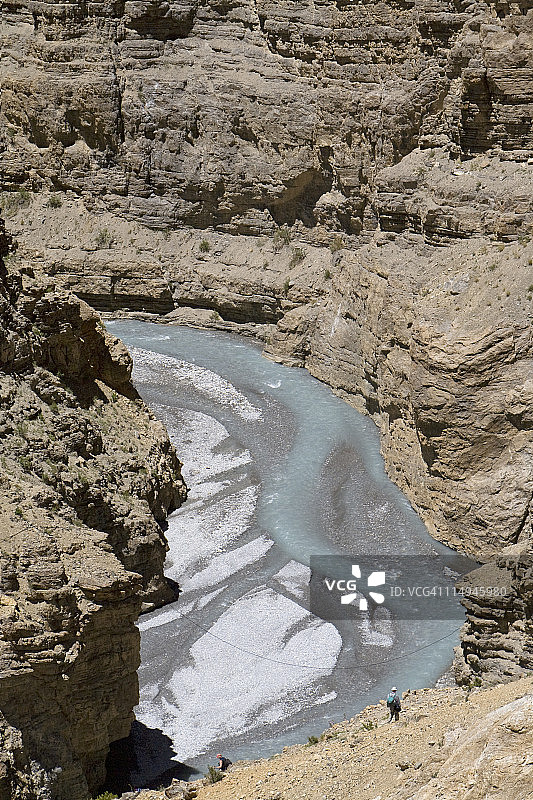 走进通往河流的岩石峡谷的男人图片素材