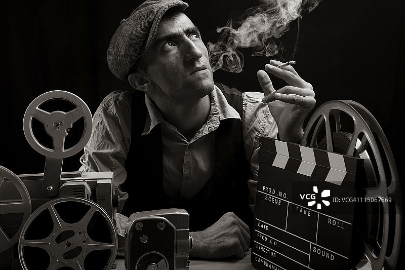 老式电影导演与电影设备合影并吸烟图片素材