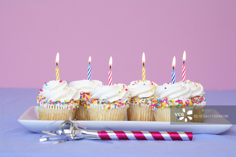 带有派对吹风机的生日纸杯蛋糕图片素材