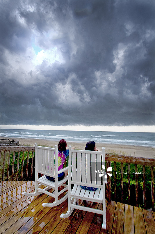 女孩们在海滩观看暴风雨图片素材