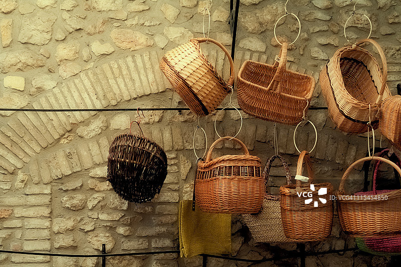 挂在石墙上的柳条筐图片素材