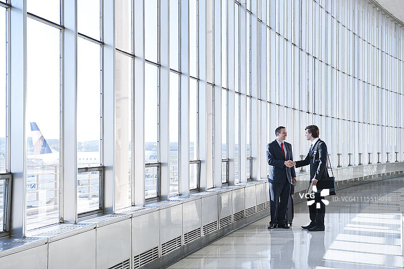 在机场握手的白人男商人们图片素材