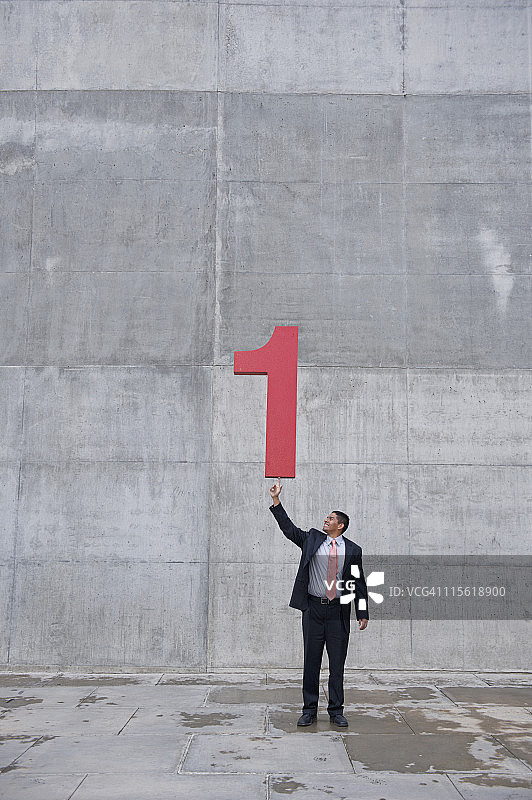 拿着大号数字1的西班牙裔商人图片素材