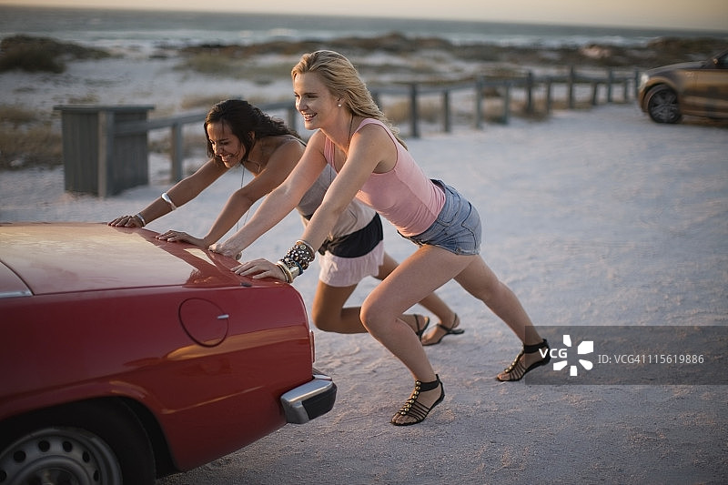 女孩们推着抛锚的汽车图片素材