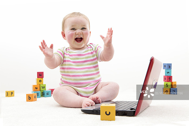 宝宝玩积木和笔记本电脑图片素材