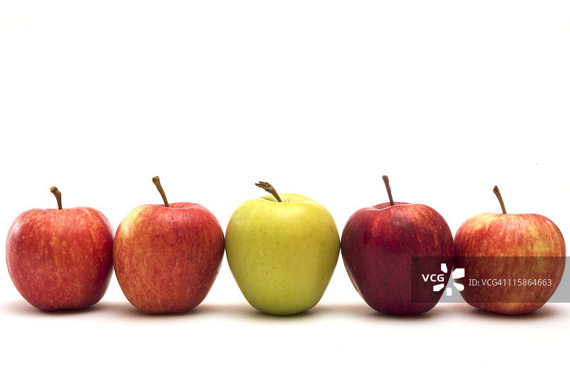 白色表面上排列的五个不同颜色的苹果图片素材