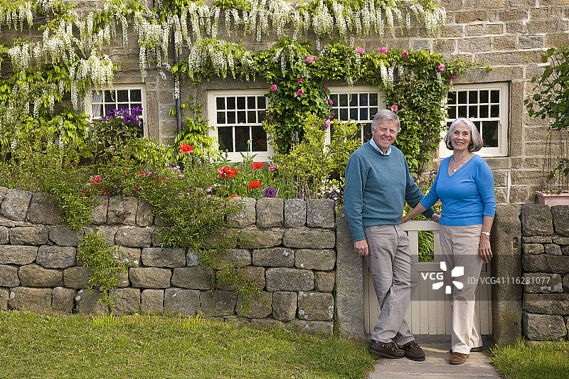 退休夫妇在乡村小屋前图片素材