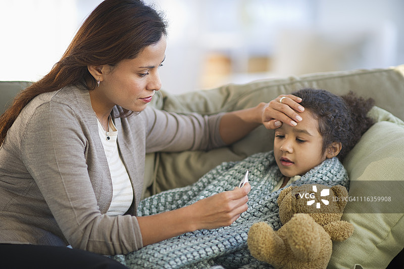 美国新泽西州泽西市，母亲为女儿（6-7岁）量体温图片素材