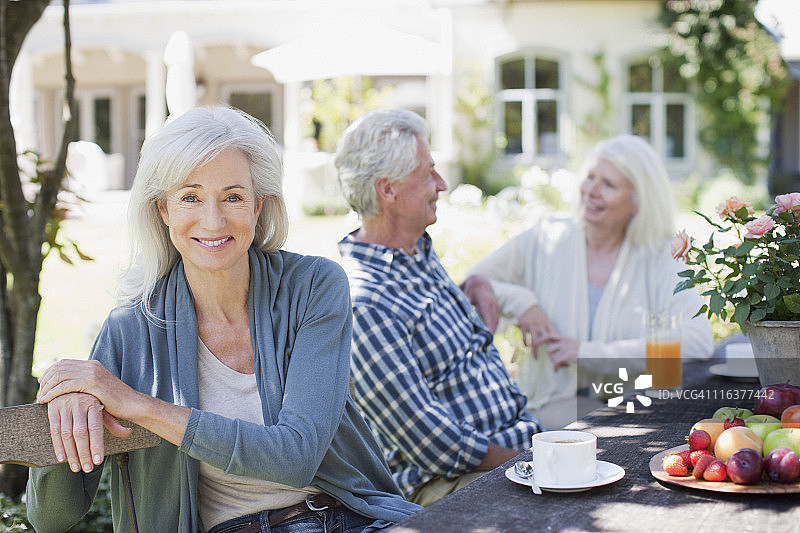 年长的朋友在花园的桌旁图片素材